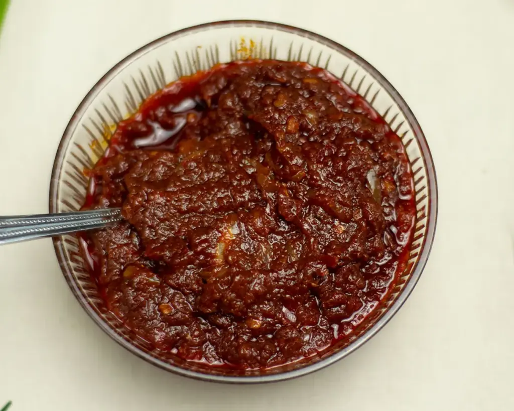 A bowl of rich, spicy sambal commonly served with nasi lemak, made with chilli paste, onions, and anchovies, known for its bold Malaysian flavour.