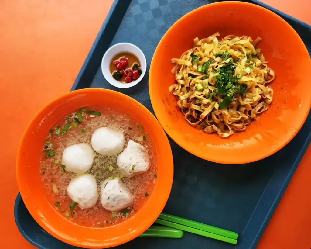 A comforting bowl of fishball noodles topped with springy fishballs, minced meat, and fresh greens, served in a light savoury broth that highlights the simplicity and flavour of this classic hawker dish.