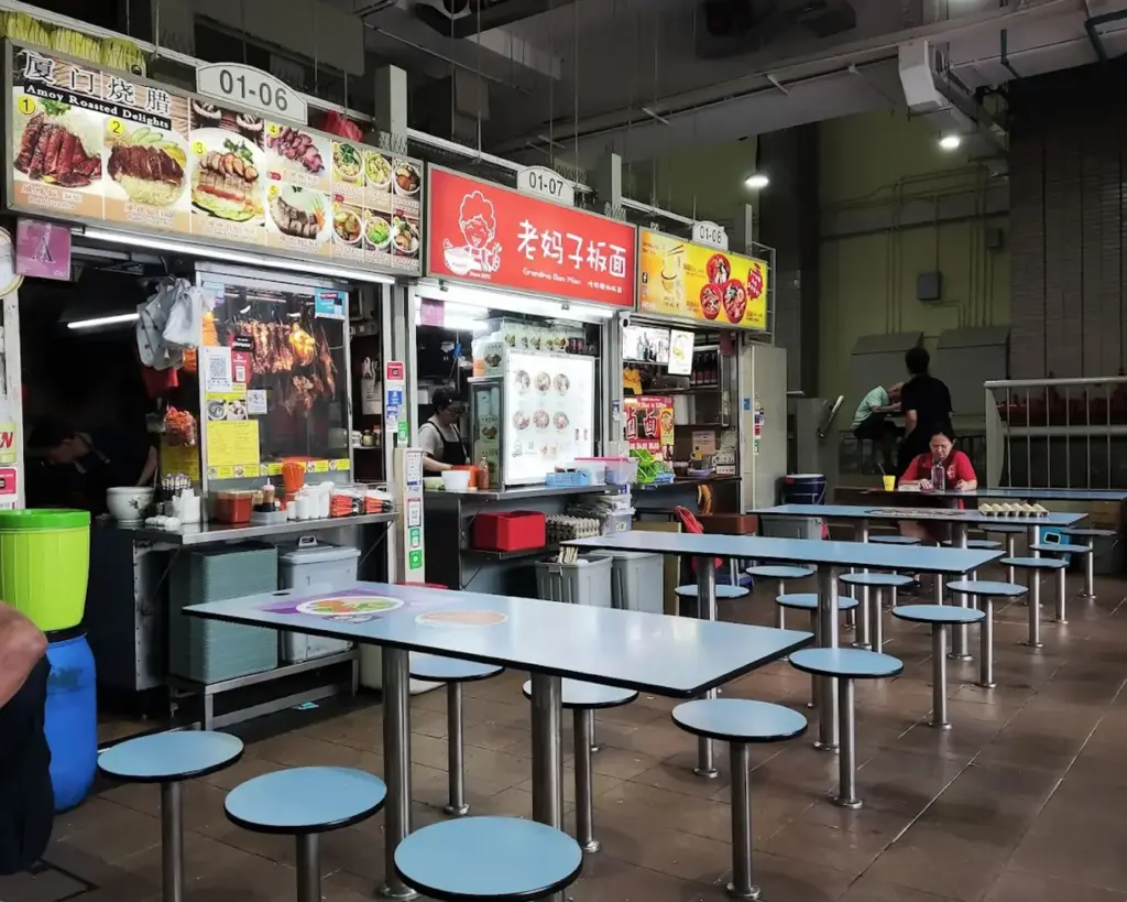 Stall 32, showcasing a modest yet vibrant setup with menu boards and food displays, representing the authentic, no-frills dining experience of local street food vendors.