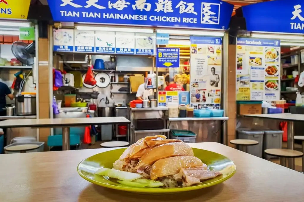 A plate of Tian Tian Hainanese chicken rice served on a green plate at the famous Tian Tian Hainanese Chicken Rice stall at Maxwell Food Centre.