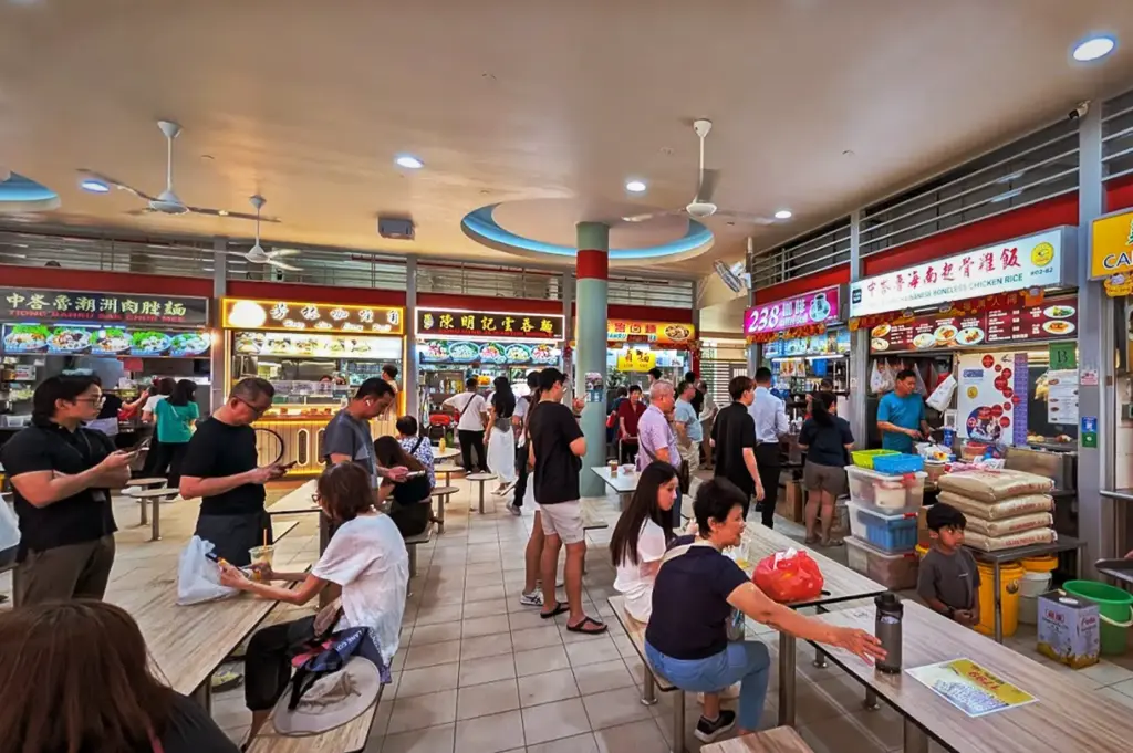 Bustling food center at Tiong Bahru Market in Singapore featuring locals dining and queuing at popular hawker stall Tiong Bahru Hainanese Boneless Chicken Rice.